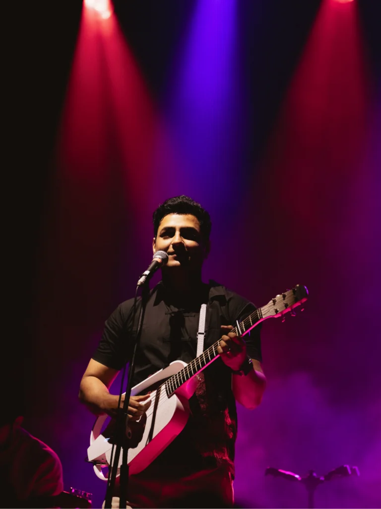Kenny Sebastian performing with a guitar during a live comedy and music show