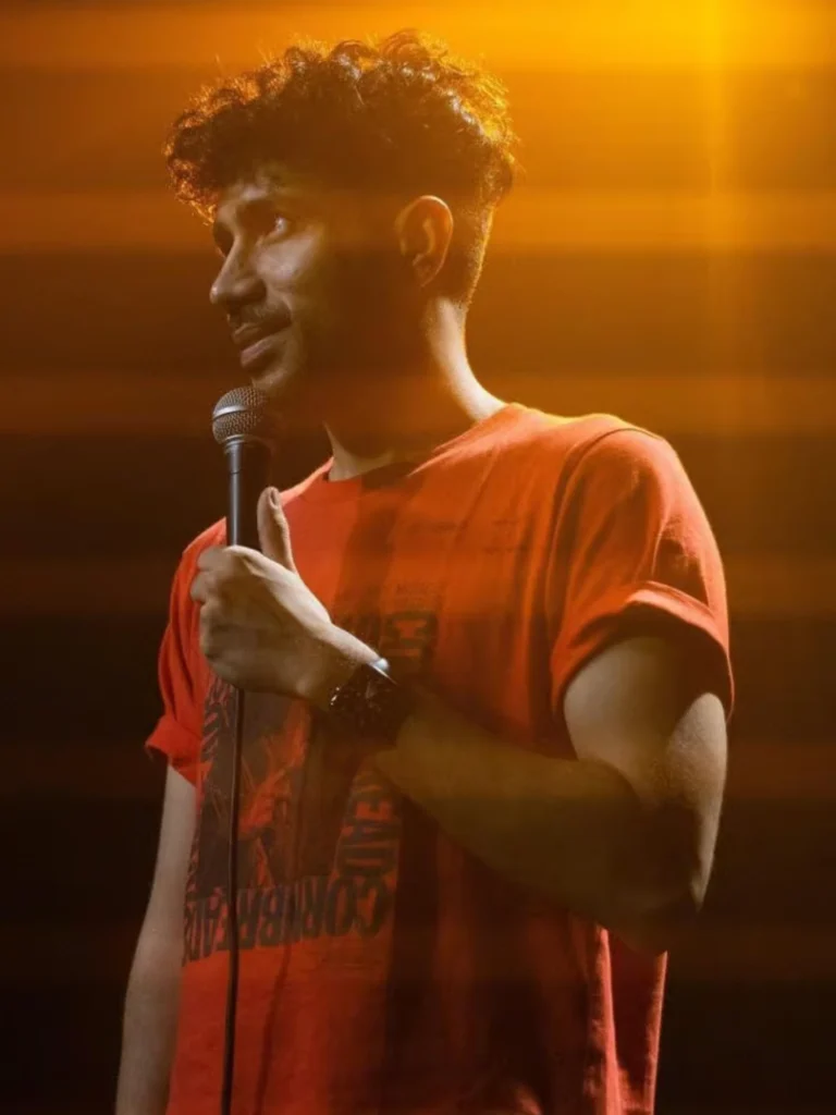 Abhishek Upmanyu performing during a live comedy show under stage lights
