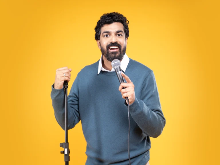 Azeem Banatwalla stand-up comedian holding microphone
