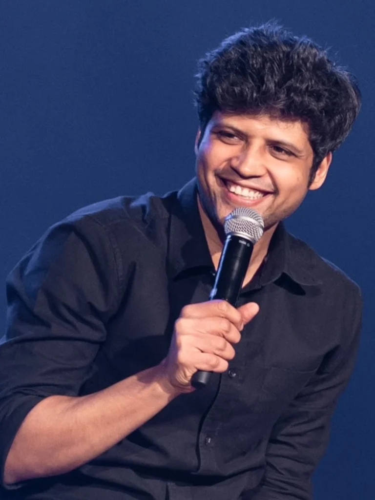 Rahul Subramanian smiling on stage with microphone