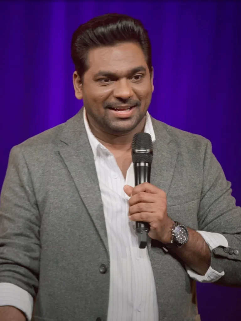 Zakir Khan performing stand-up comedy on stage with microphone