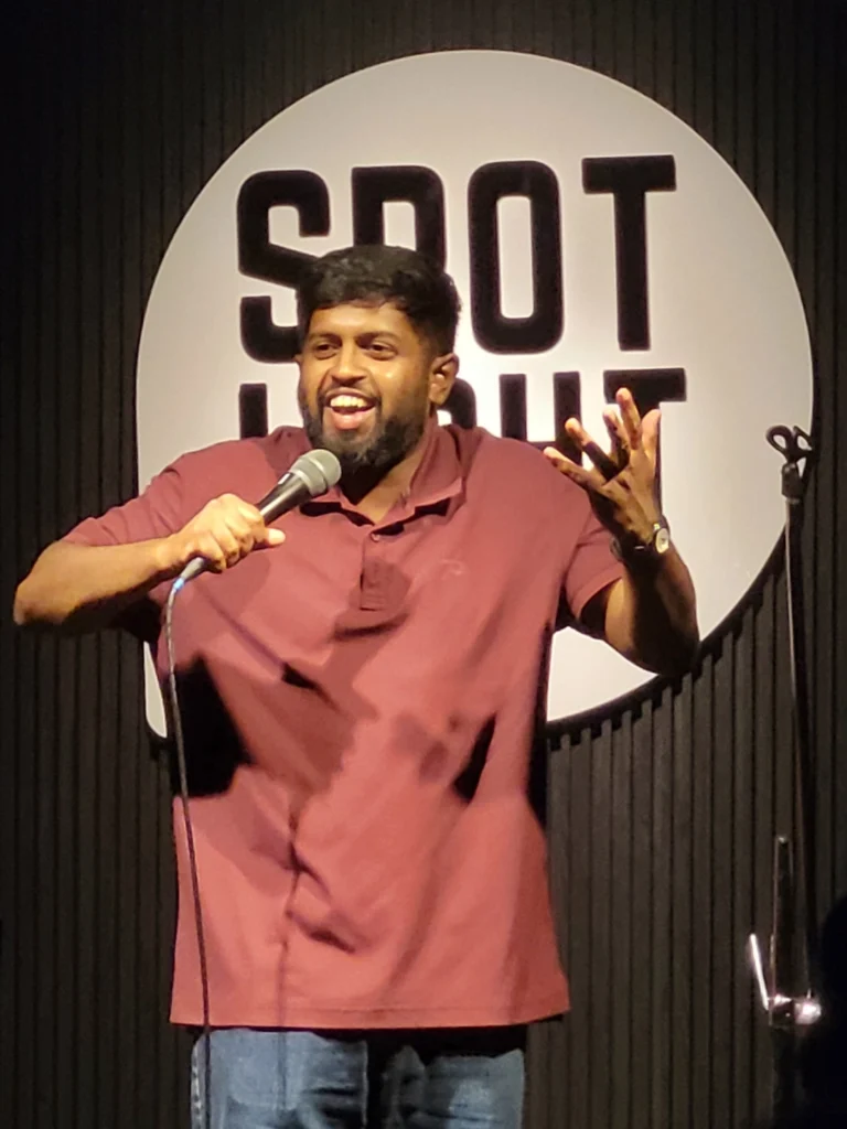 Anand Rathnam performing stand-up comedy at Spotlight Socials in Kochi.