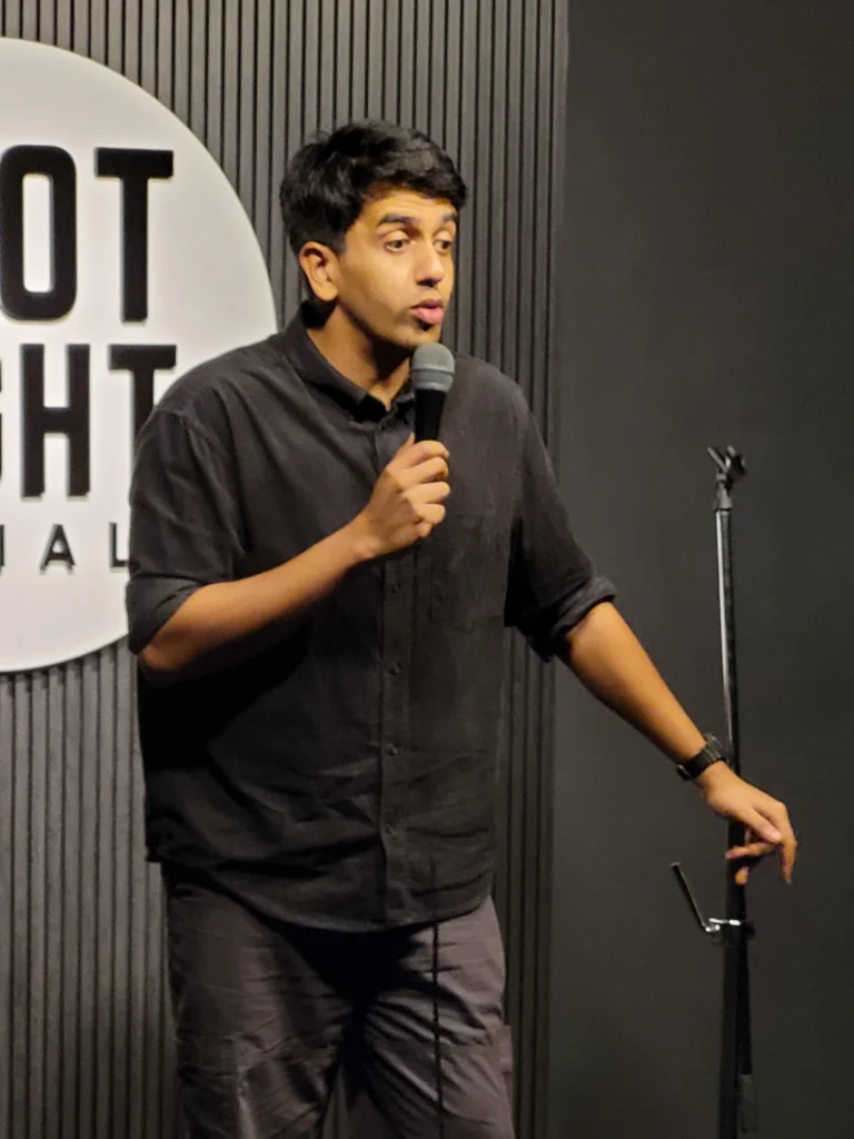 Gautham Govindan performing stand-up comedy live at Spotlight Socials in Kochi.