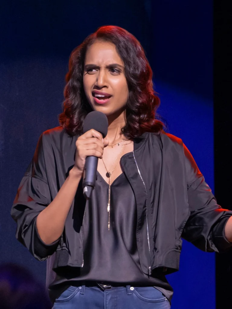 Niveditha Prakasam performing stand-up comedy on stage.