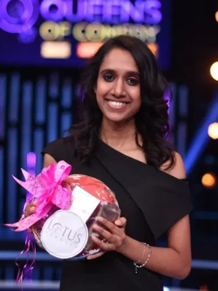 Niveditha Prakasam holding a prize after appearing on Queens of Comedy.