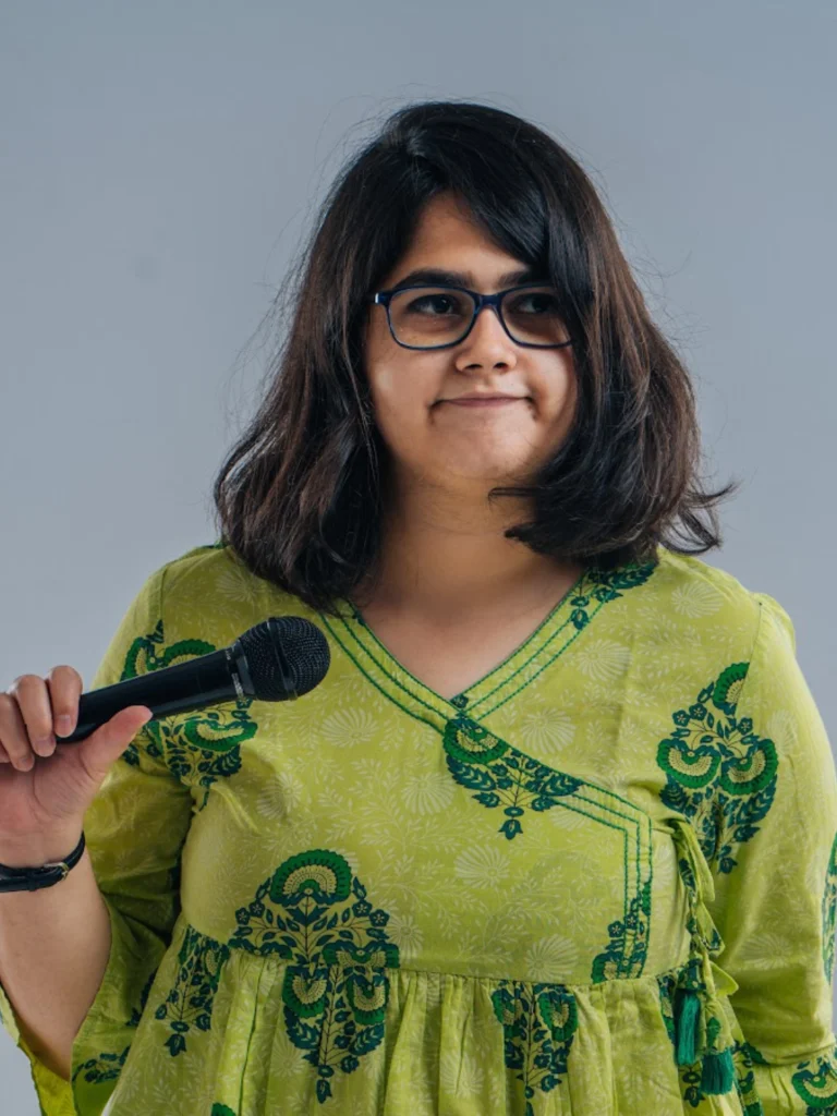 Portrait of stand-up comedian Shreeja Chaturvedi holding a microphone.