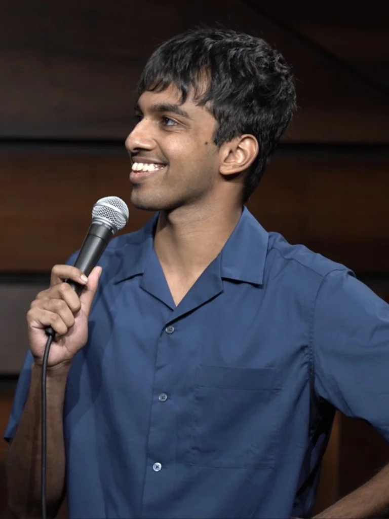 Tarang Hardikar performing stand-up comedy with a microphone.